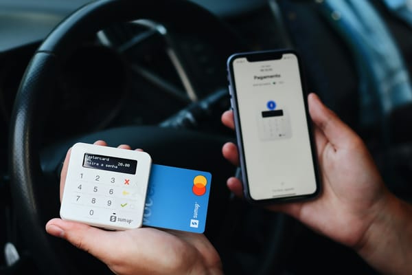 Pessoa segurando cartão de pagamento e smartphone, ilustrando segurança em transações digitais