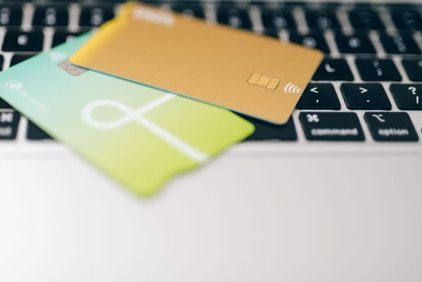 Cartões bancários sobre notebook e pessoa realizando compras online