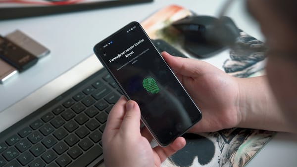 Pessoa utilizando sensor de impressão digital em smartphone, ilustrando autenticação sem senha