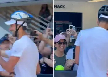 Novak Djokovic greets fans wearing a helmet after getting hit on head with water bottle