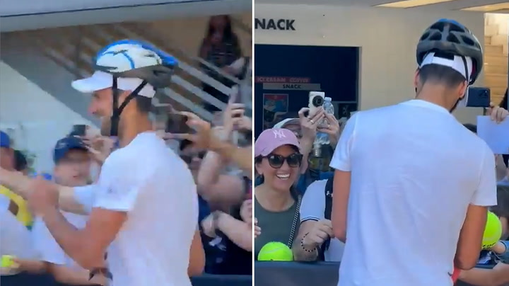 Novak Djokovic cumprimenta fas usando capacete apos incidente com garrafa